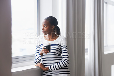 Buy stock photo A thoughtful young woman gazing out of a window on her coffee break