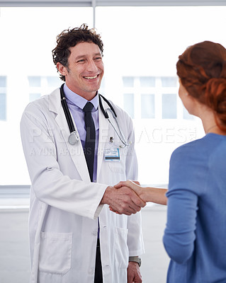 Buy stock photo Cropped shot of a doctor and shaking his patient's hand