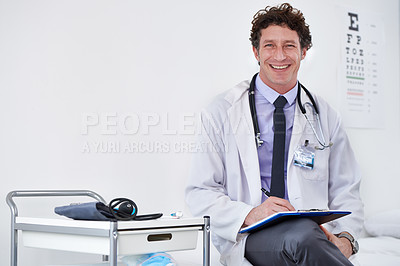 Buy stock photo Portrait of a male doctor reading a report