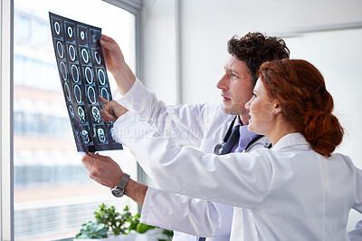 Buy stock photo Doctors, brain scan and reading for results at hospital with pointing, teamwork and health by window. Neurologist, partner and medic with mri for wellness, check and decision with document in clinic