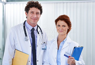 Buy stock photo Cropped shot of two doctors looking happily at the camera