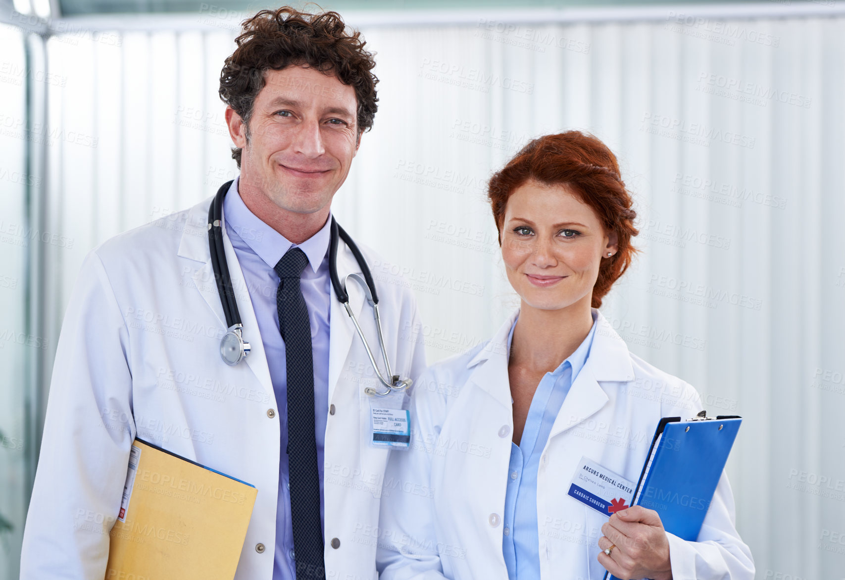Buy stock photo Cropped shot of two doctors looking happily at the camera