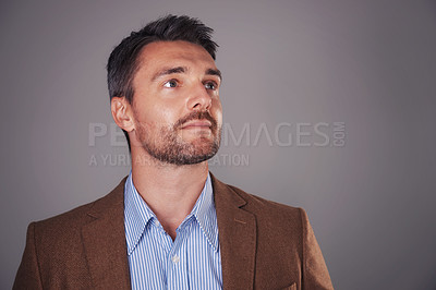 Buy stock photo Studio shot of a man deep in thought against a gray background