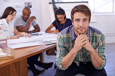 Buy stock photo Portrait of a handsome male architect with his colleagues working in the background