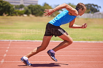 Buy stock photo Action shot of a young male athlete sprinting in a track race