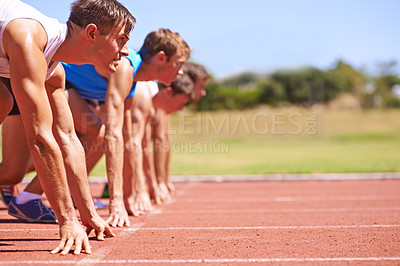 Buy stock photo Cropped side view of a group of athletes at the start of a track race