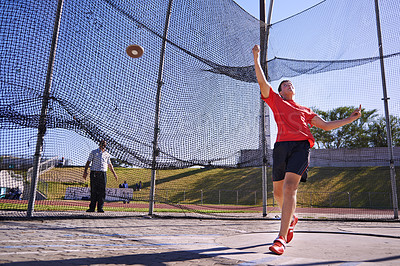 Buy stock photo Shot of a young sportsman throwing a discus