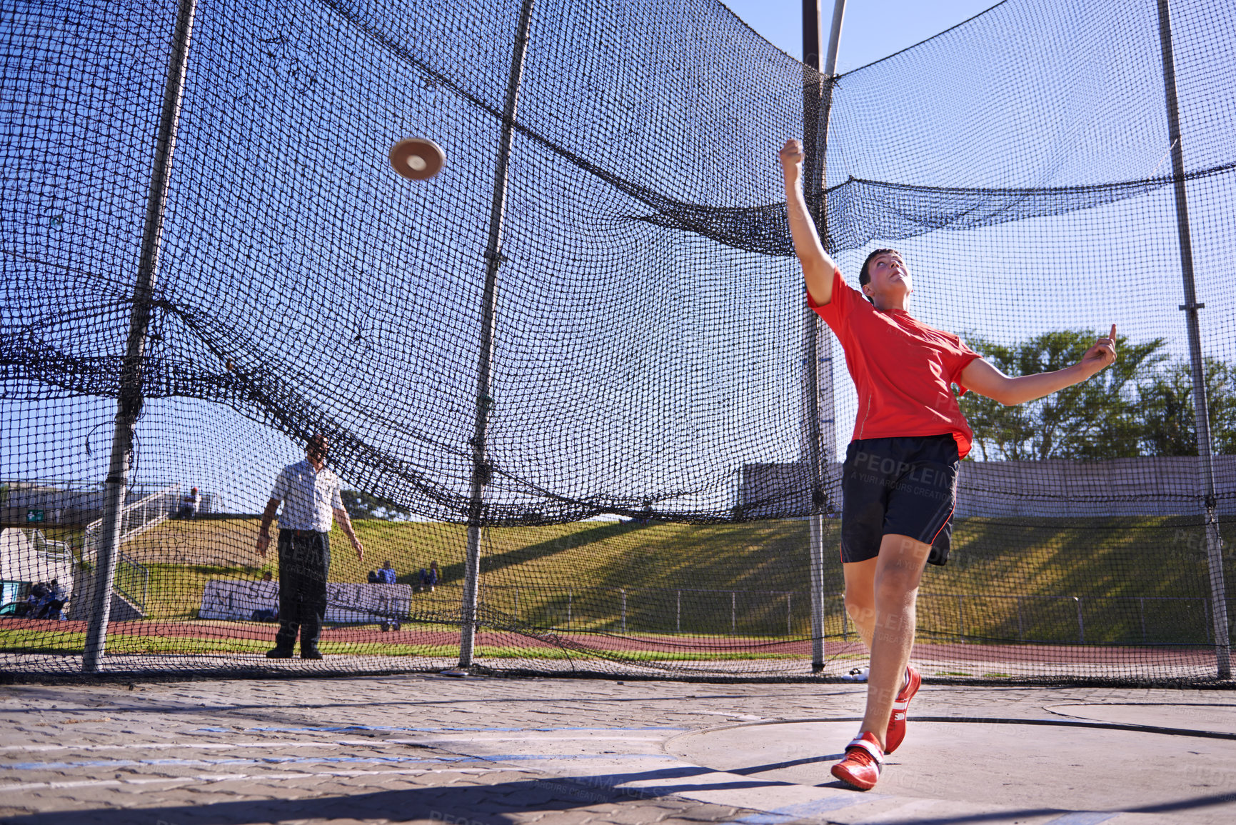 Buy stock photo Shot of a young sportsman throwing a discus