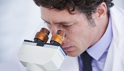 Buy stock photo A scientist observing something through a microcope