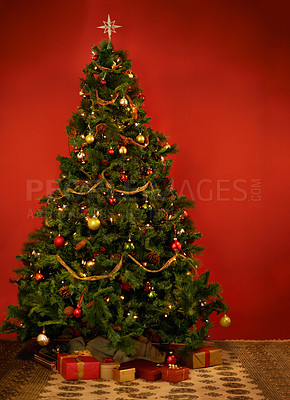 Buy stock photo Studio shot of a decorated Christmas tree with gifts underneath it