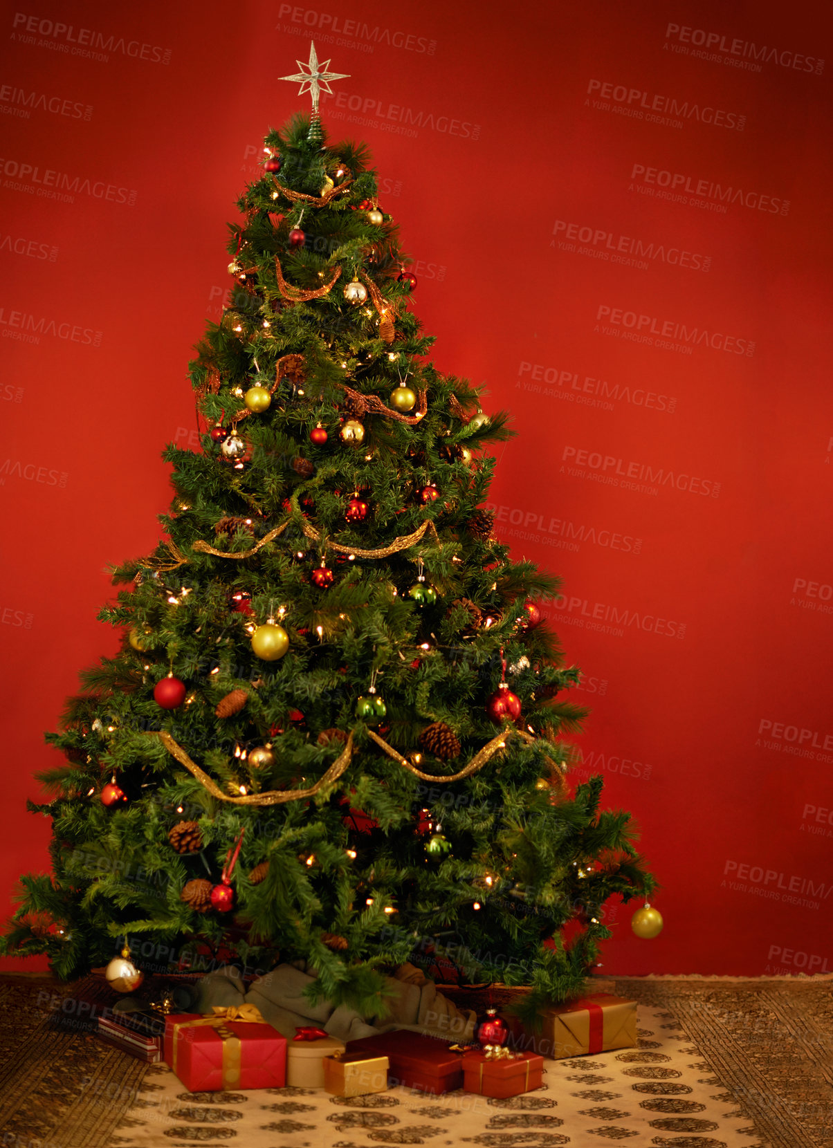 Buy stock photo Studio shot of a decorated Christmas tree with gifts underneath it