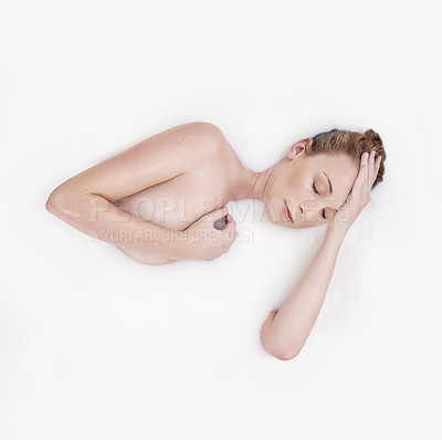 Buy stock photo Studio shot of an attractive woman submerged in a white liquid