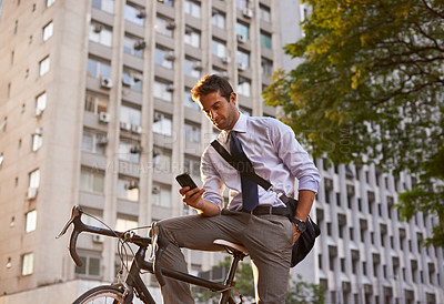 Buy stock photo Bicycle, businessman and smartphone for sustainable travel, transportation and communication in city. Cellphone, commute and male employee on bike for cycling, carbon neutral or texting in urban town