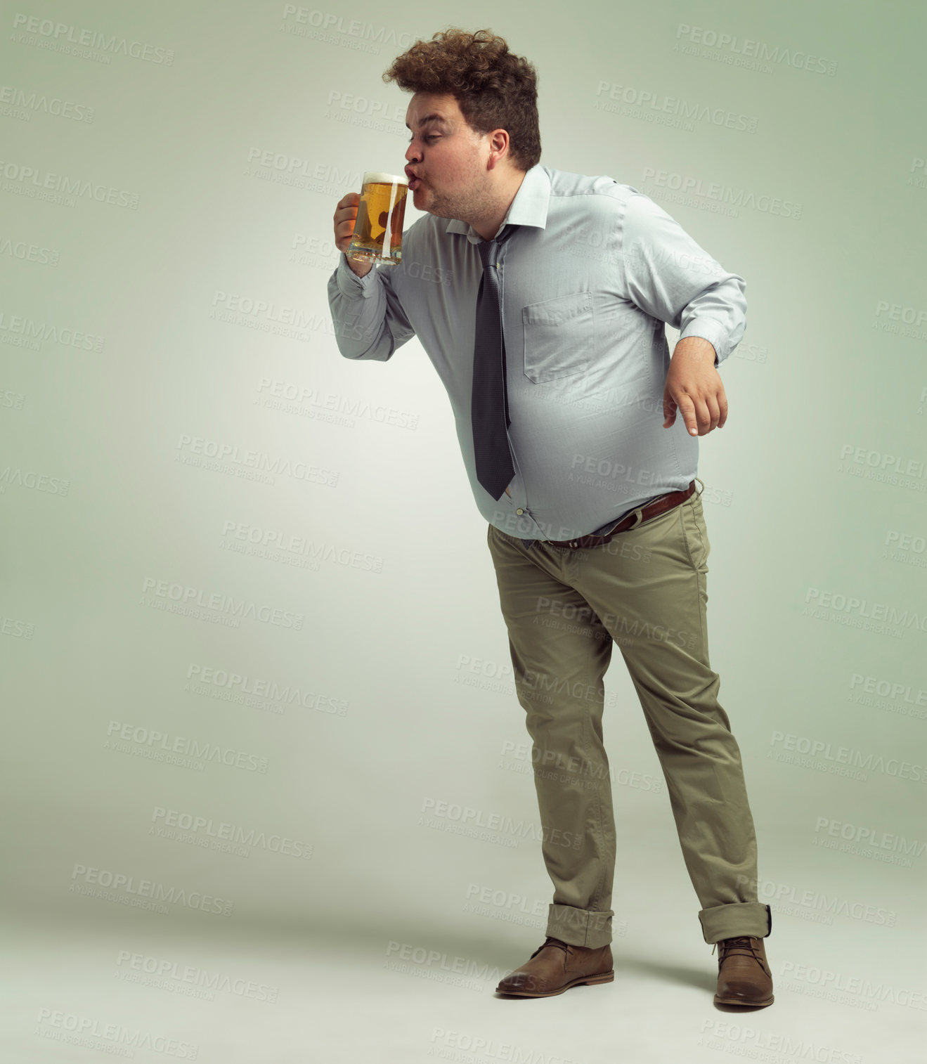 Buy stock photo Goofy, drunk and man with beer to drink, alcohol and professional with pint, mockup and break for event. Studio background, fun and celebration for employee, person and silly in party and New Year