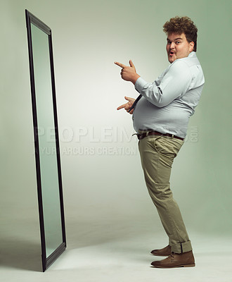 Buy stock photo Mirror, portrait and man positive, pointing and double chin with happiness for reflection in studio. Overweight, plus size and male person with obesity, comic and excited to change unhealthy life