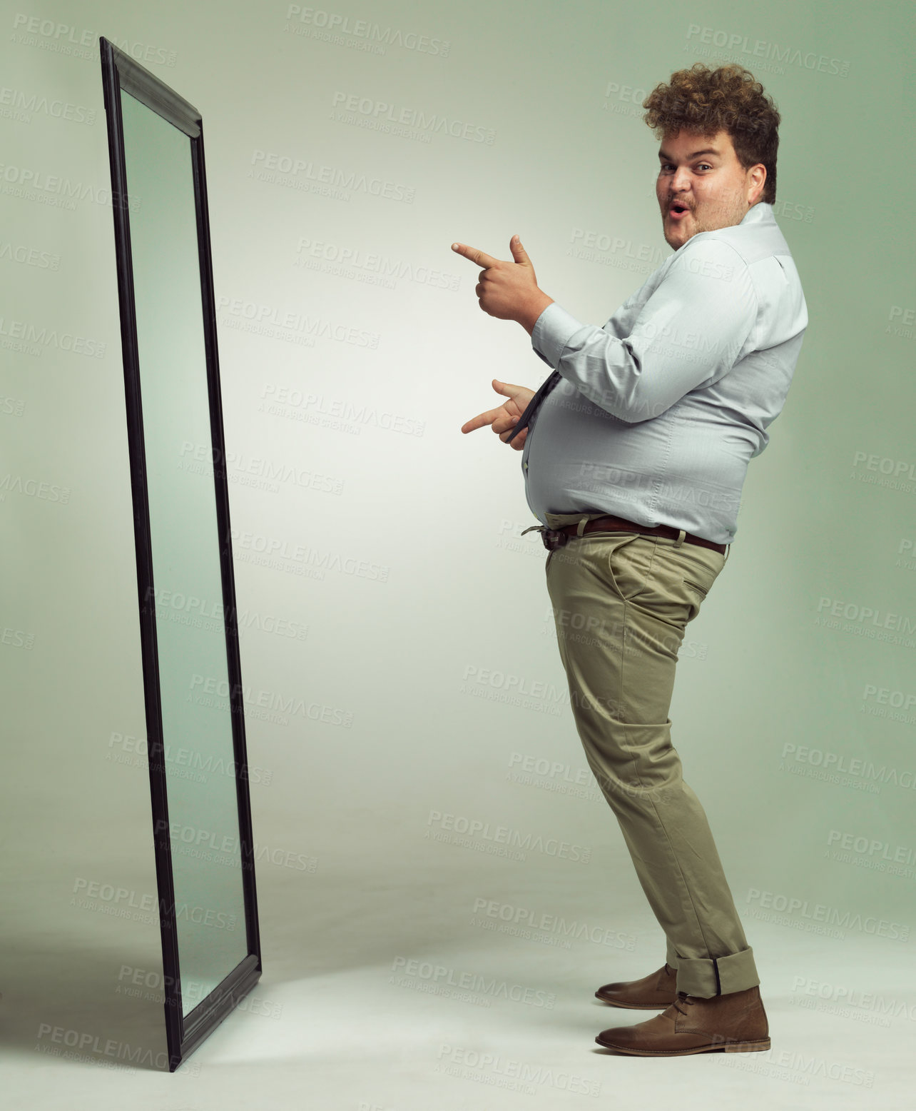 Buy stock photo Mirror, portrait and man positive, pointing and double chin with happiness for reflection in studio. Overweight, plus size and male person with obesity, comic and excited to change unhealthy life