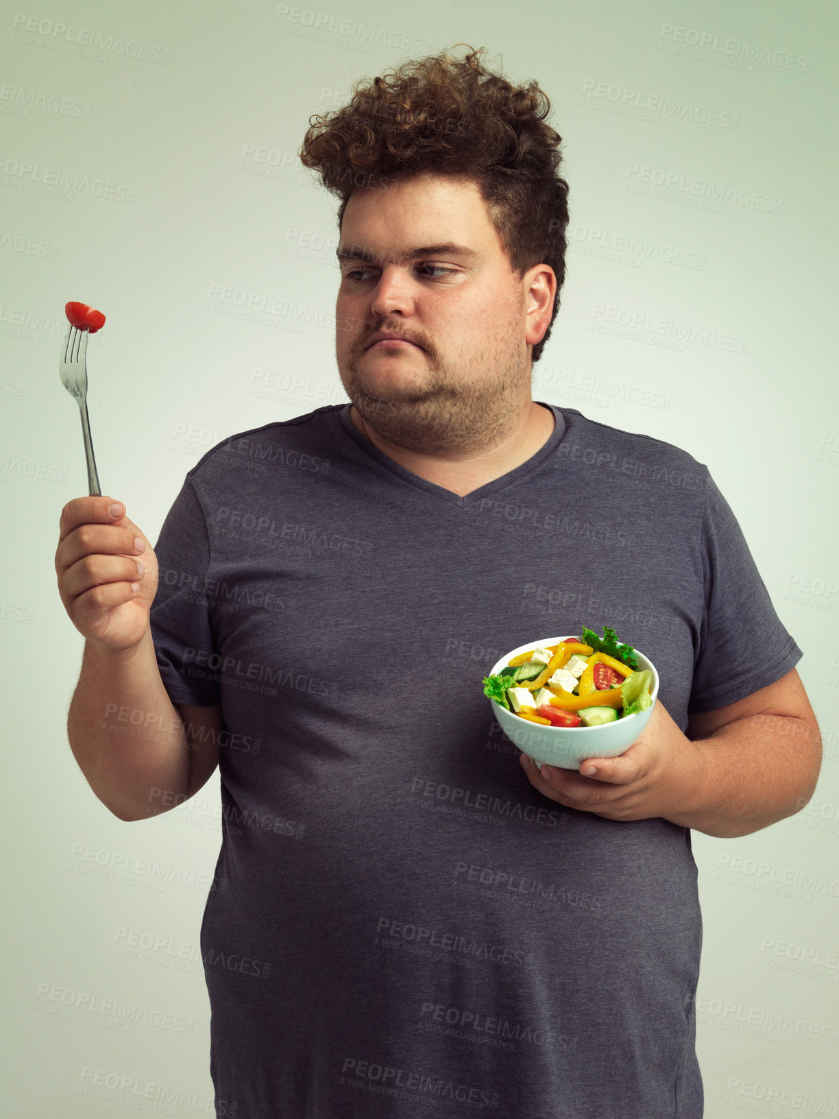 Buy stock photo Unhappy, man and salad in studio for weight loss, healthy food and organic nutrition for wellness. Male person, plus size and disgust with meal for vitamin c, detox or lifestyle change for diet