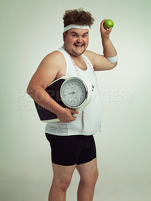 Buy stock photo Scale, happy man and portrait with apple for fitness, health or nutrition isolated on gray studio background mockup. Plus size, fruit or diet for weight loss of body of male person with tape measure