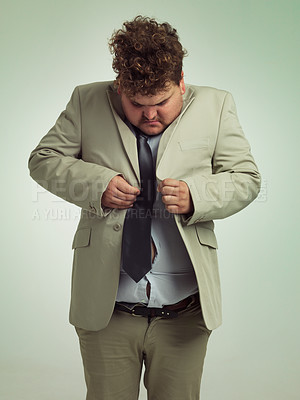 Buy stock photo Shot of an overweight man in a suit trying to button his jacket