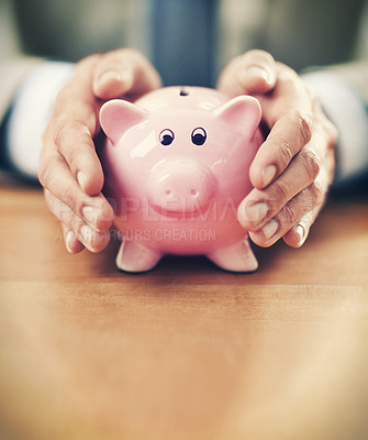 Buy stock photo Cropped image of a businessman's hands covering his piggybank