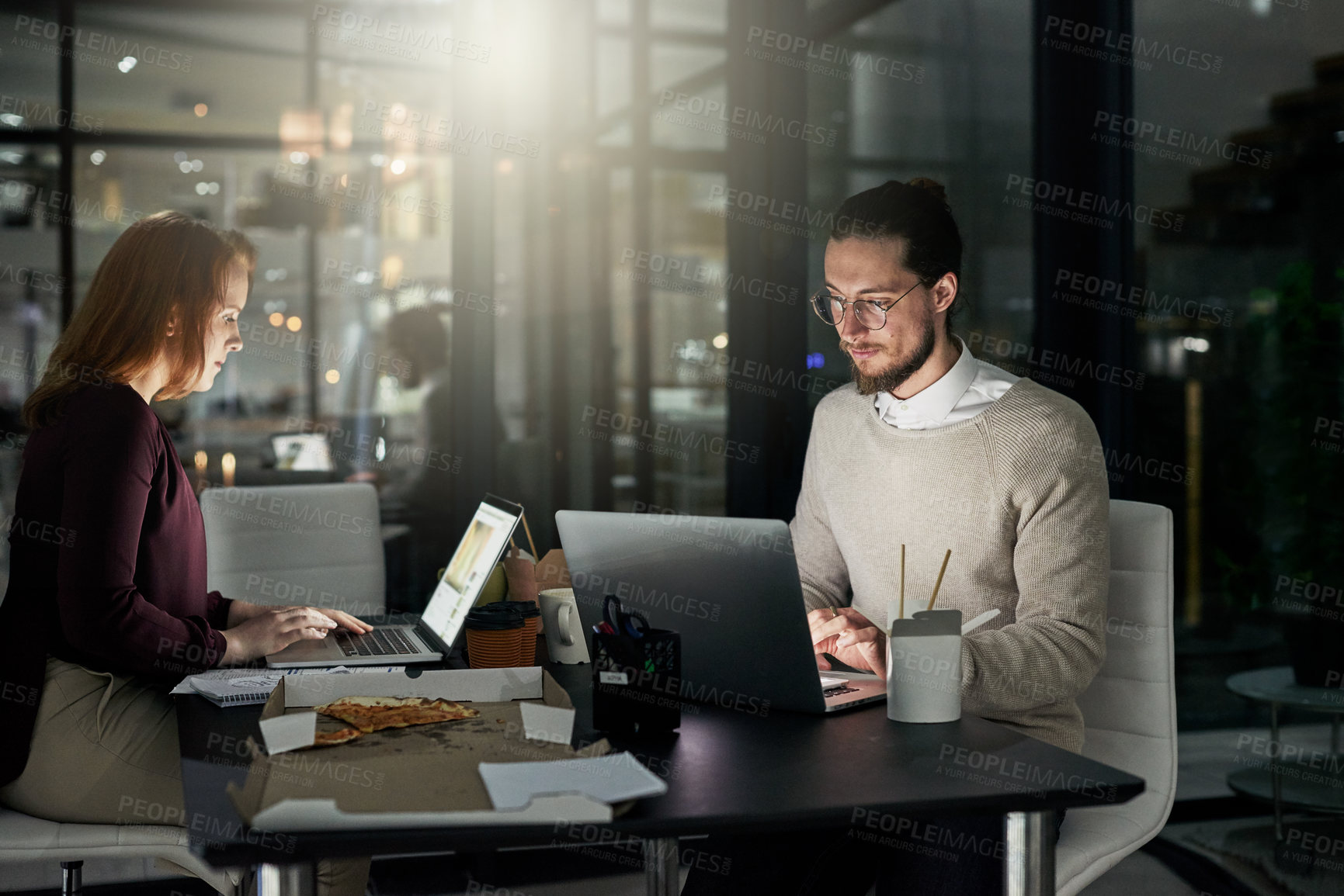 Buy stock photo Shot of two young designers working late in the office