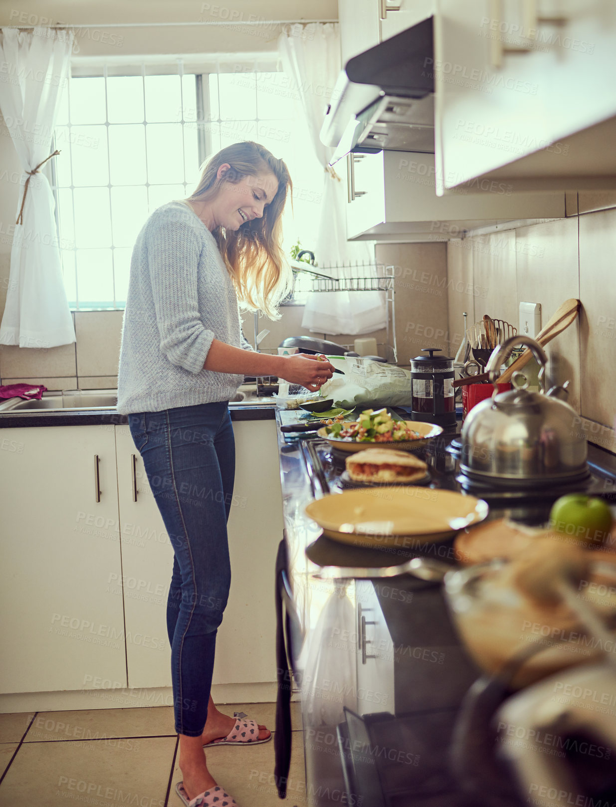 Buy stock photo Shot of an attractive young woman preparing a nutritious meal at home