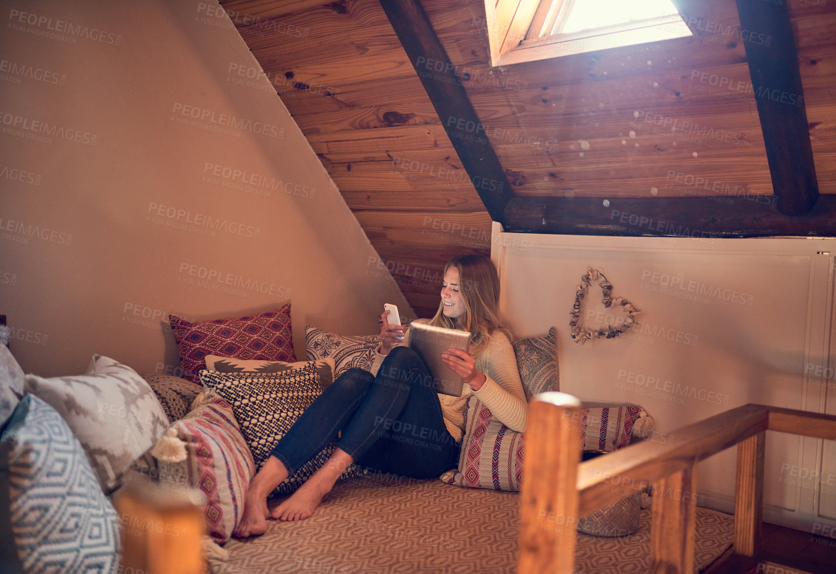 Buy stock photo Shot of a young woman texting on her smartphone while relaxing in her bedroom at home