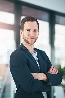 Buy stock photo Portrait of a successful businessman standing with his arms folded in the office