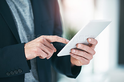 Buy stock photo Shot of an unrecognizable businessman using his tablet the office