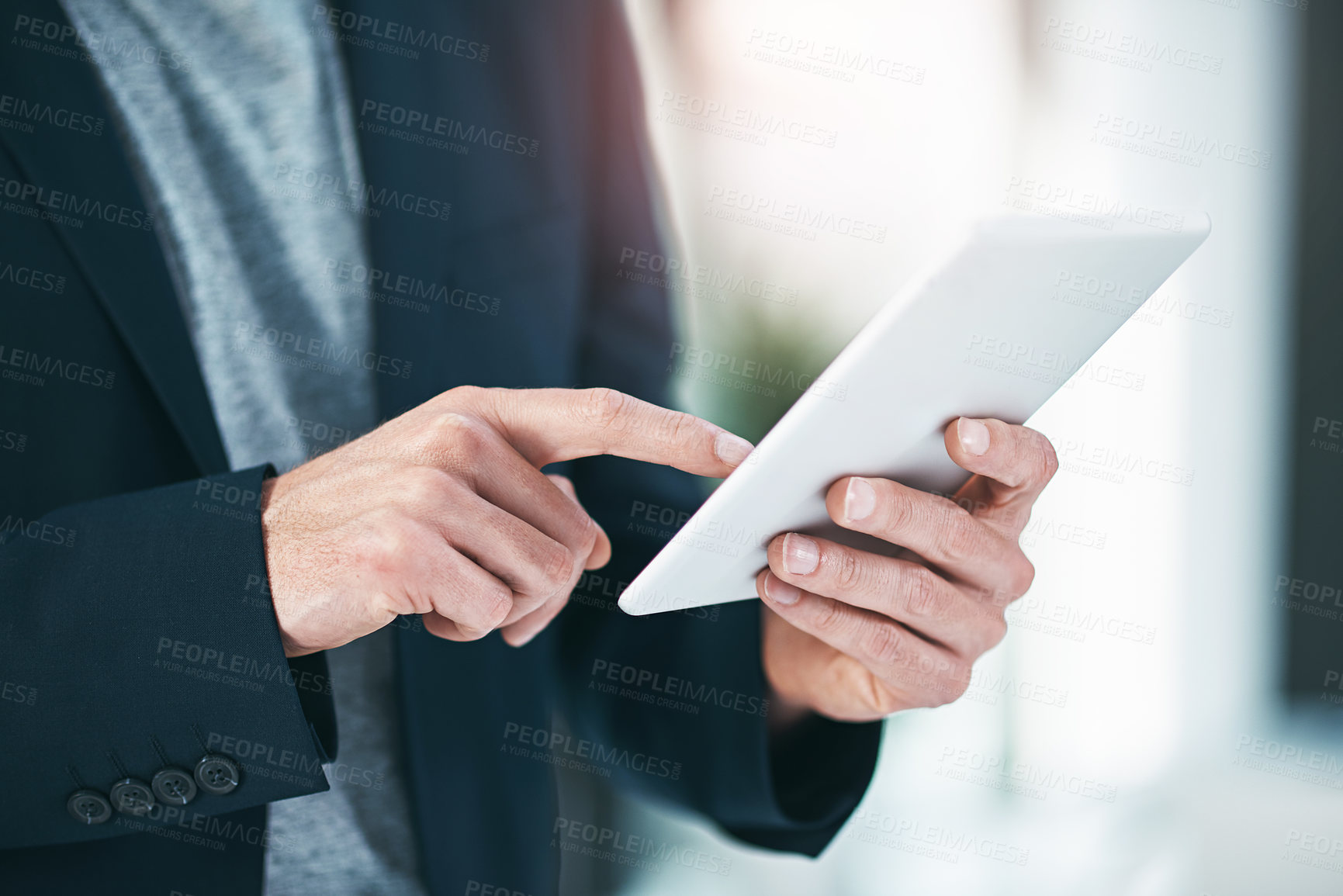 Buy stock photo Shot of an unrecognizable businessman using his tablet the office