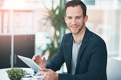 Buy stock photo Portrait of a successful businessman using his tablet the office