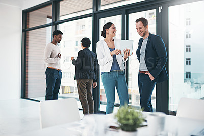 Buy stock photo Shot of businesspeople discussing something on a tablet