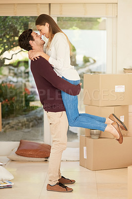 Buy stock photo Shot of an affectionate young couple embracing while moving into a new home