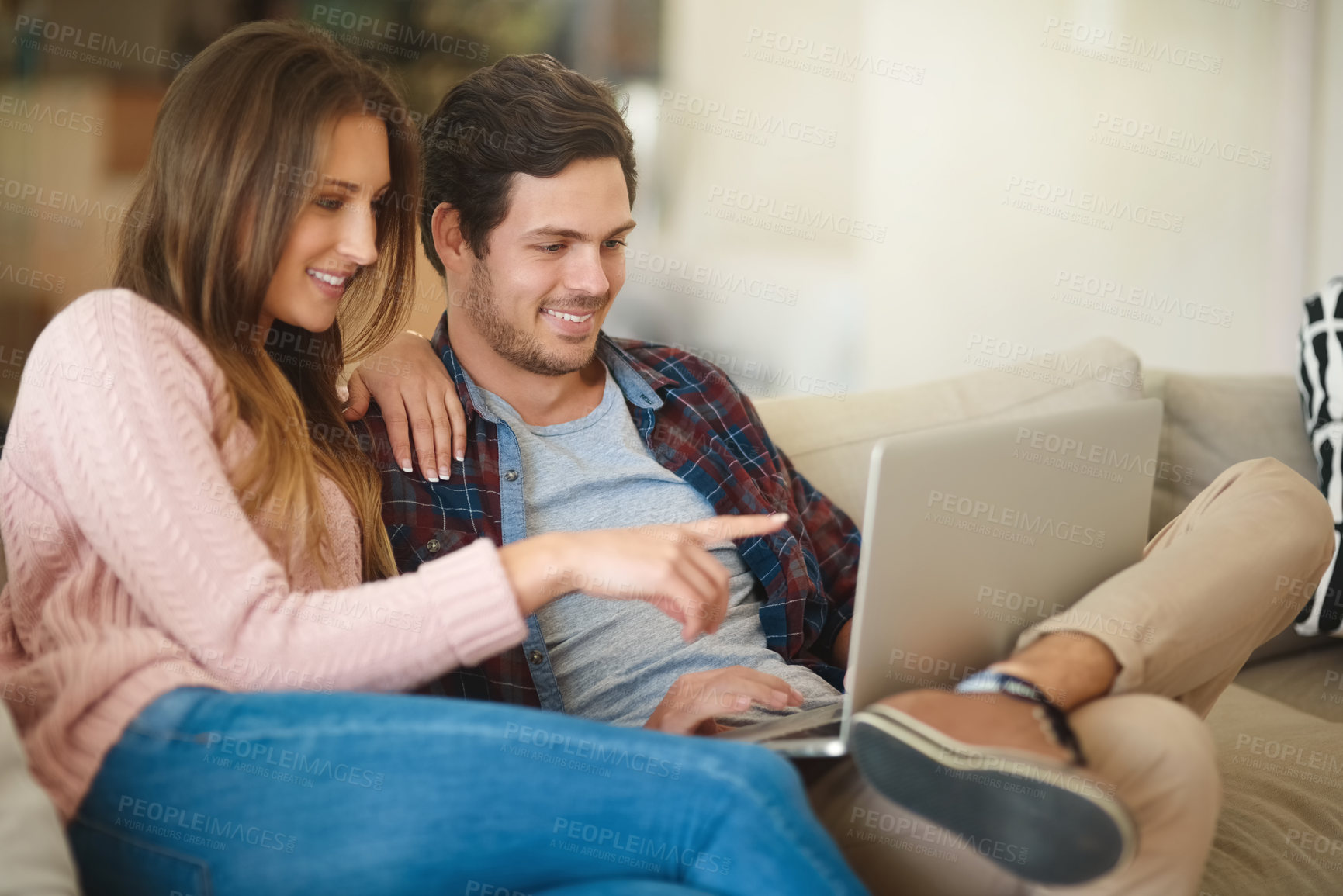 Buy stock photo Shot of a happy young couple using a laptop together while relaxing on the   sofa at home