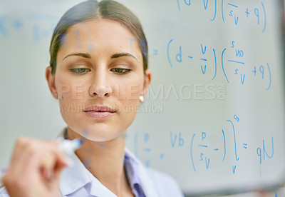 Buy stock photo Cropped shot of a young female scientist writing equations on a glass wall in a lab