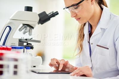 Buy stock photo Cropped shot of a young female scientist recording her findings on a digital tablet