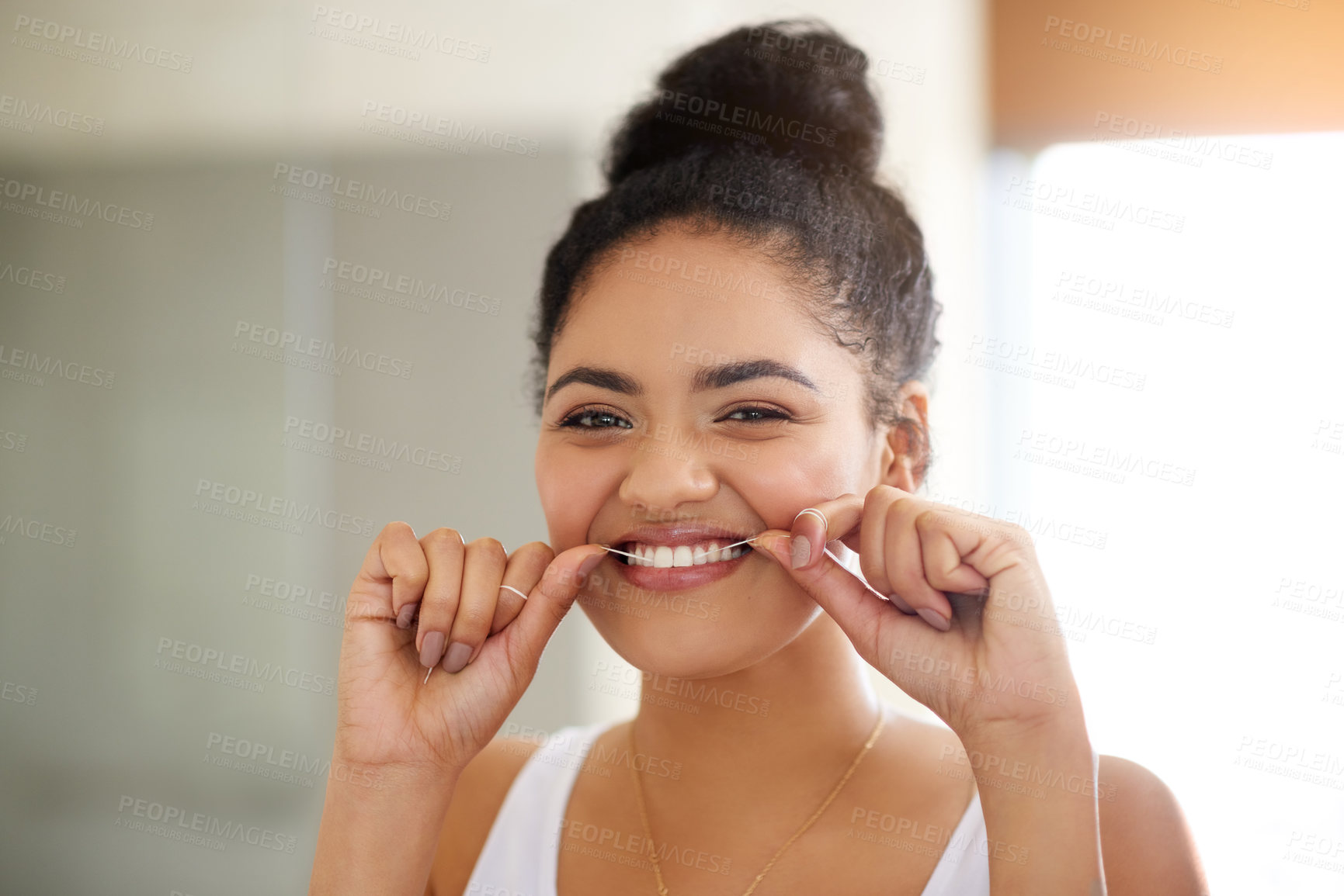 Buy stock photo Shot of an attractive and happy young woman flossing her teeth