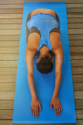 Buy stock photo High angle shot of a young woman practising yoga at home