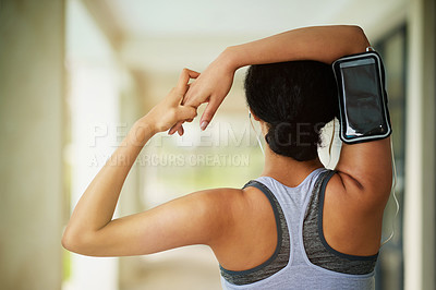 Buy stock photo Rear view shot of a sporty young woman warming up before a run