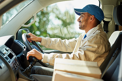 Buy stock photo Shot of a happy delivery man driving his van with boxes in the front seat