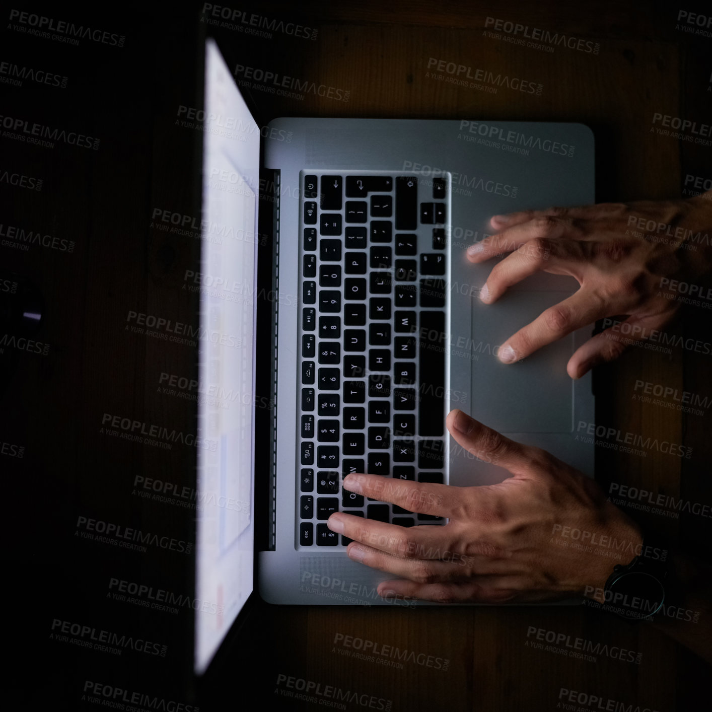 Buy stock photo High angle shot of a man working late on a laptop against a dark background