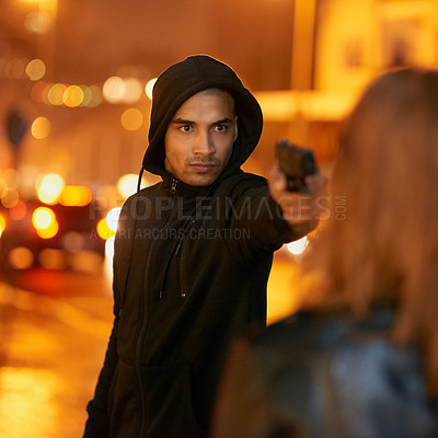 Buy stock photo Shot of a thief threatening a young woman at gunpoint in the city
