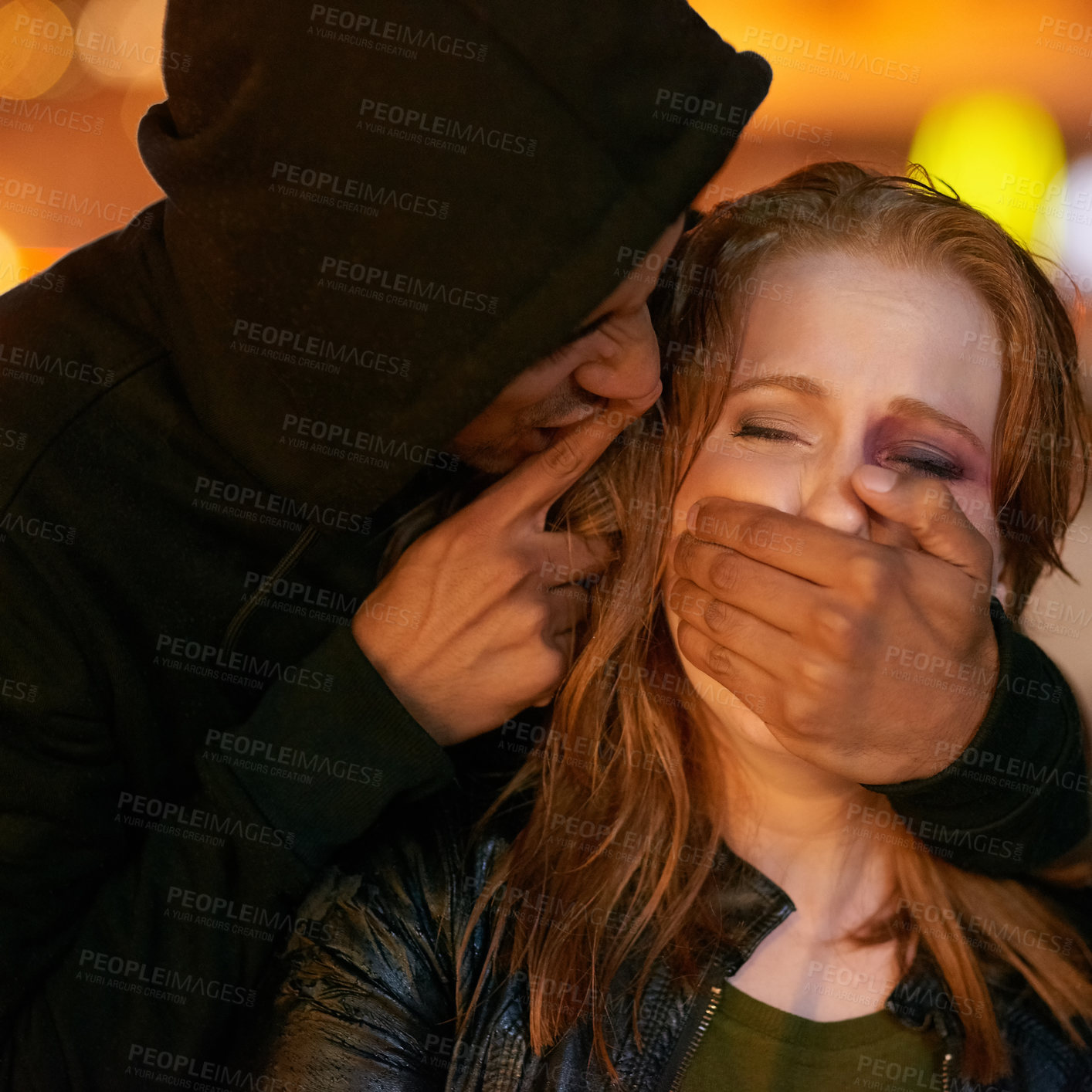 Buy stock photo Shot of a hooded criminal grabbing his victim while gesturing for her to be quiet