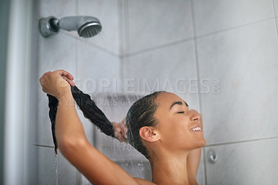 Buy stock photo Cropped shot of a young woman washing her hair while taking a shower