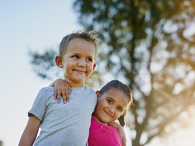Buy stock photo Shot of a little brother and sister walking arm and arm together in a park