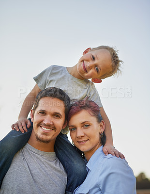 Buy stock photo Portrait of smiling mother and father carrying there little boy on their shoulders outside