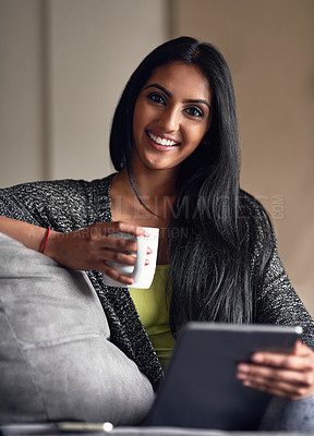 Buy stock photo Portrait of an attractive young woman surfing the net while sitting on her sofa at home