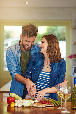 Buy stock photo Shot of a happy young couple preparing a healthy meal together at home