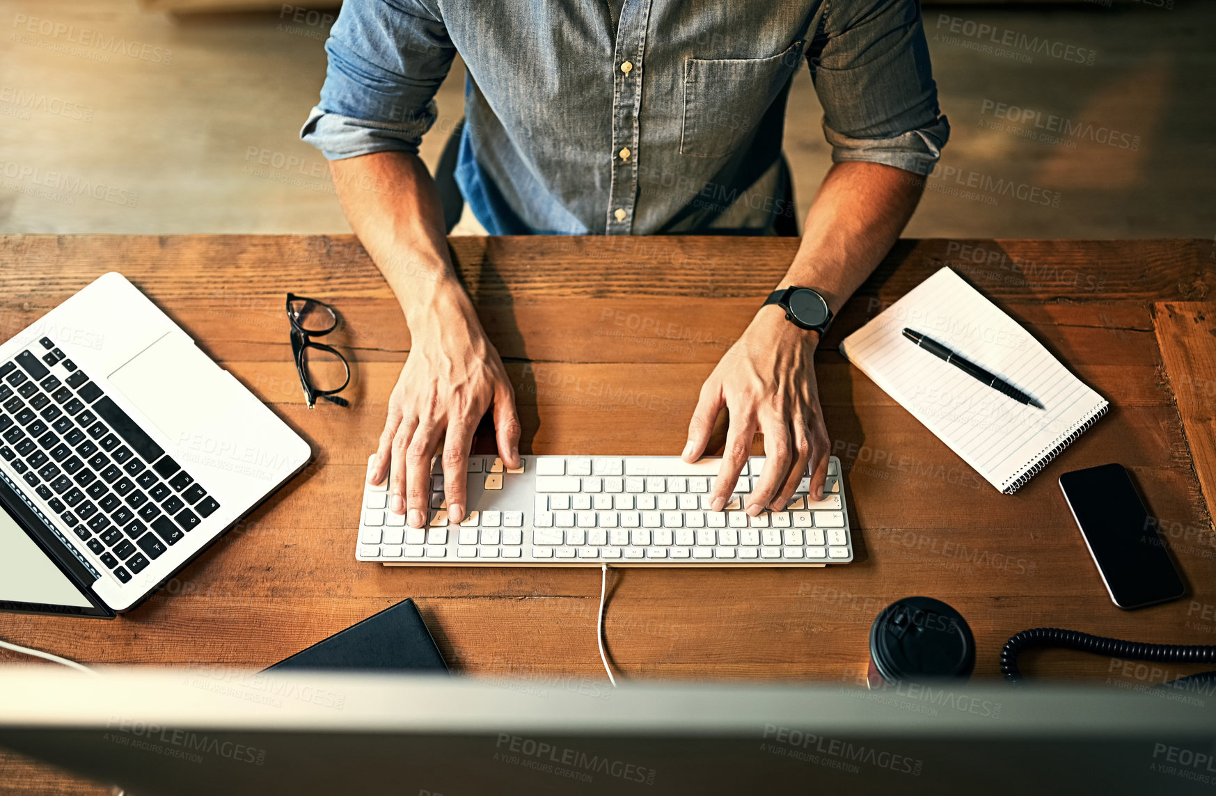 Buy stock photo Busy businessman typing on computer keyboard with hands late at night while working, planning and checking email at an office desk job. Productive corporate worker using latest technology