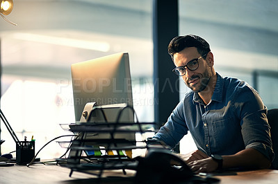 Buy stock photo Portrait of a young businessman using a computer during a late night at work